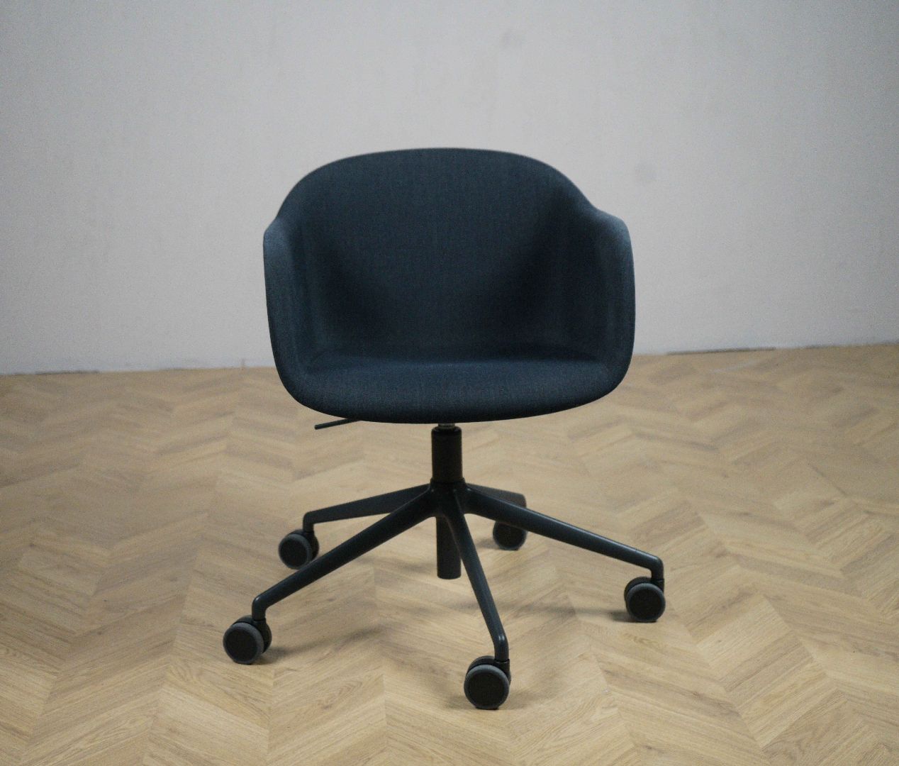 Muuto Fiber kontorstol i mørkeblå med sort dreje- og hjulstel, set forfra.